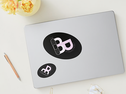 Laptop with mockup sticker design of a B and P making a heart with a bandaid
