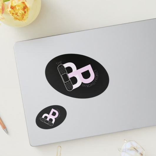 Laptop with mockup sticker design of a B and P making a heart with a bandaid